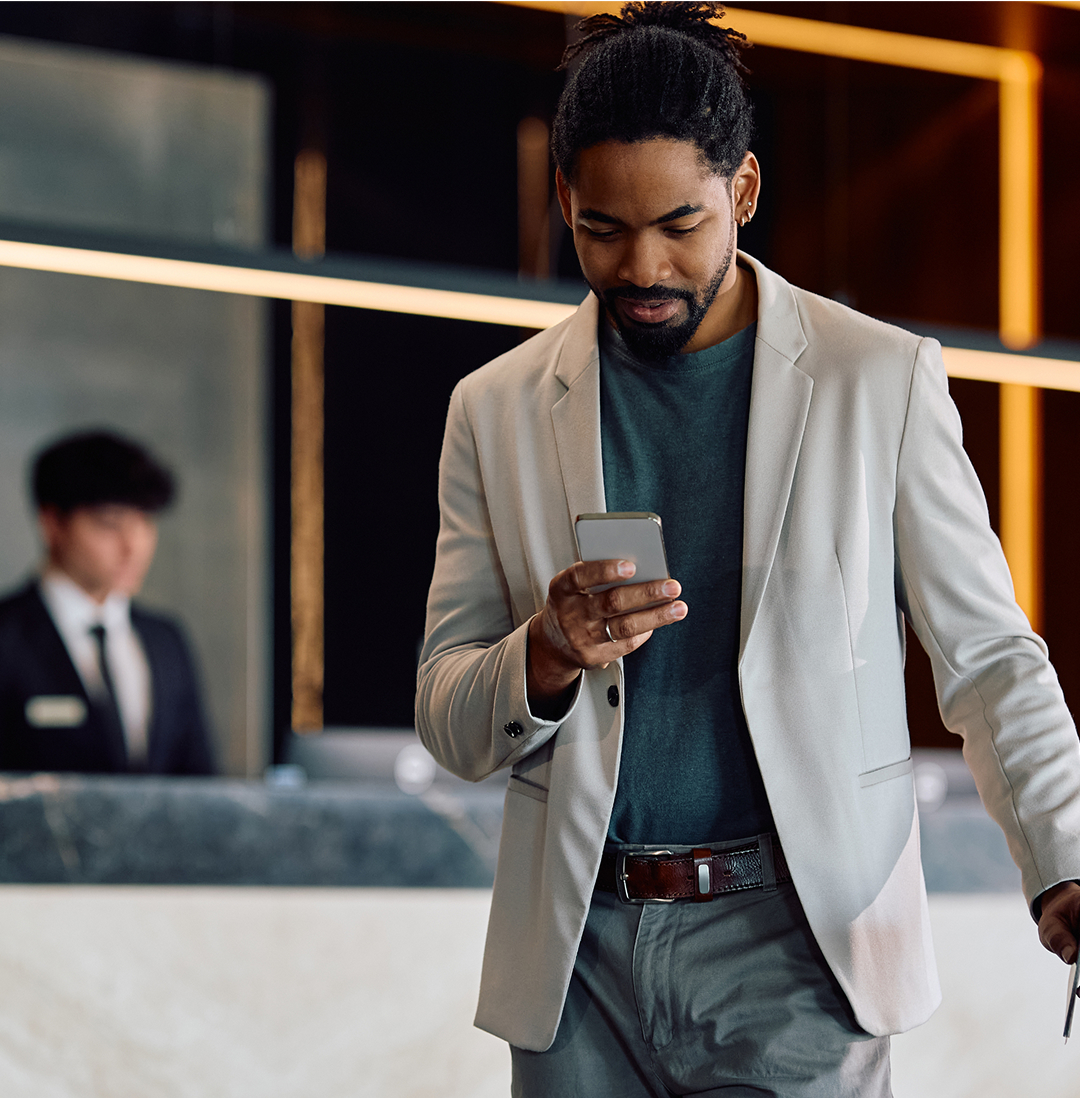 man looking at his phone dressing white with black half overlay alt